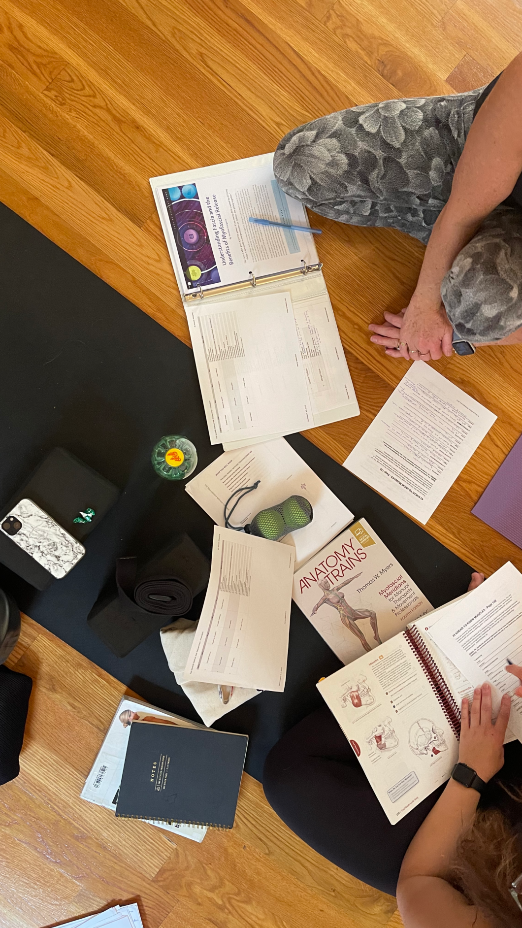 Several anatomy books laid out on the floor as students look for information.